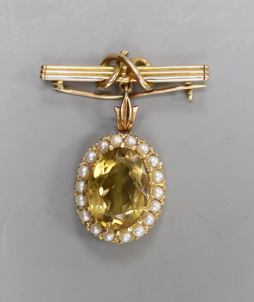 An early 20th century yellow metal, citrine and split pearl set oval pendant, overall 33mm, on a yellow metal suspension bar brooch, gross weight 8.9 grams.